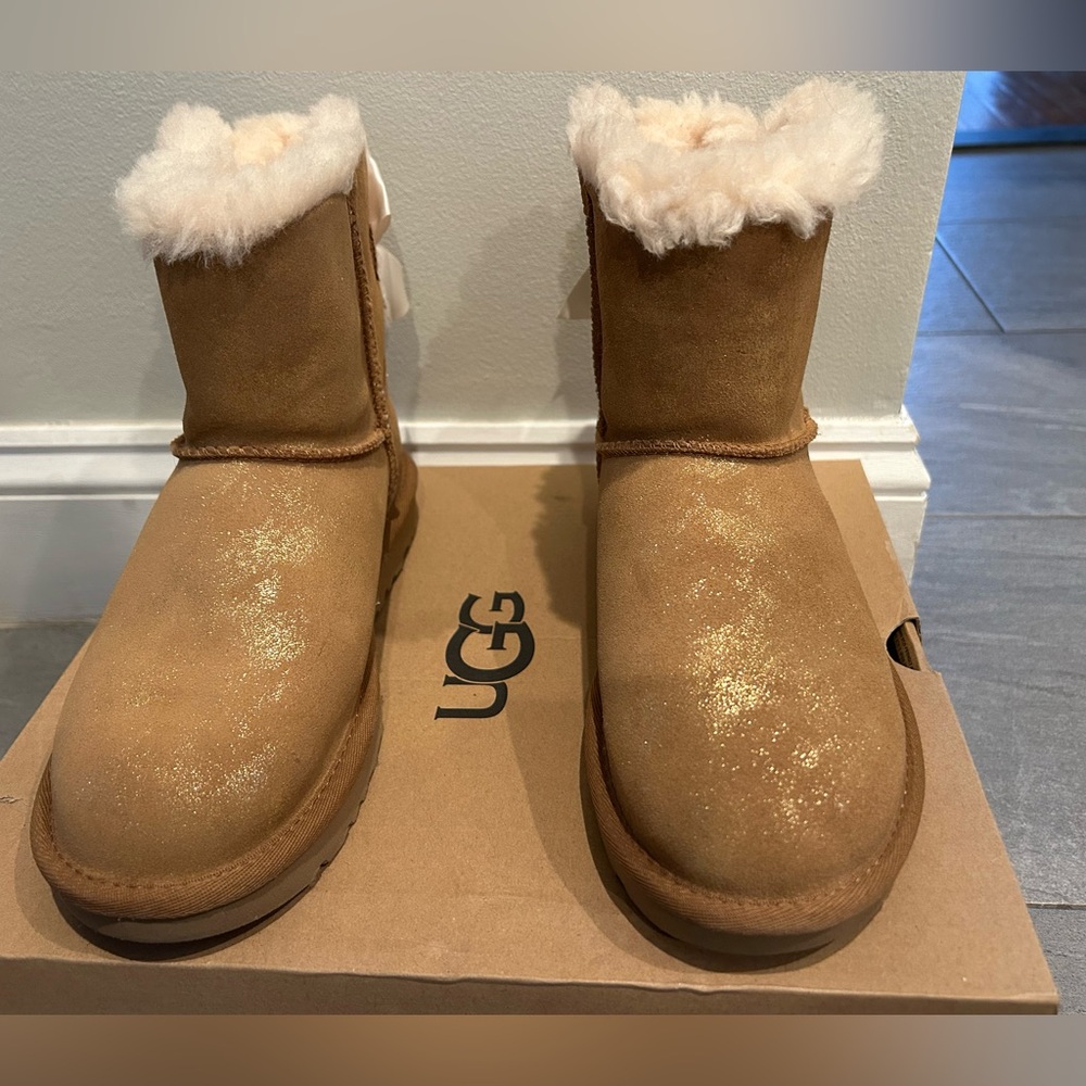 NWT UGG boots. Tan with glitter and bow on back. Never worn, size 6.